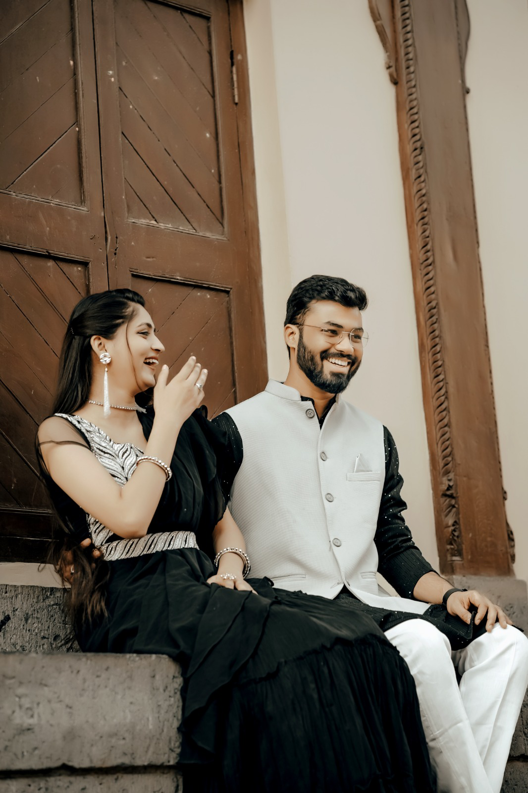Pre-wedding couple laughing together on heritage steps